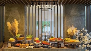 A buffet setup with various food items and decorative plants. - Canalis Suvarnabhumi Airport Hotel – Free Scheduled shuttle from Hotel to Suvarnabhumi Airport (Bangkok)