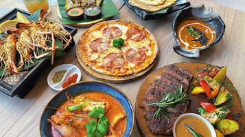 Diversa varietat de plats, incloent marisc, pizza, entrecot i un bol de sopa, que indica una àmplia oferta gastronòmica.