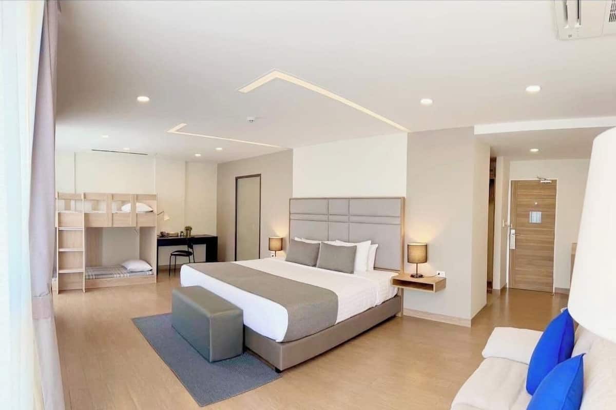 Une chambre moderne avec un grand lit, des tables de chevet, un bureau et un lit superposé.
