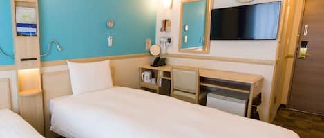 A hotel room with two beds, a desk, a mirror, a clock, and an air conditioning unit.
