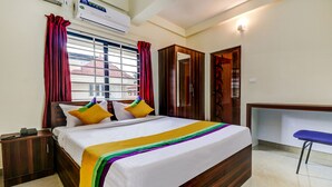 A hotel room with a bed, a desk, and a chair. - Itsy Hotels Rain Tulsi Stayz, Palarivattom Junction (Kanayannur)