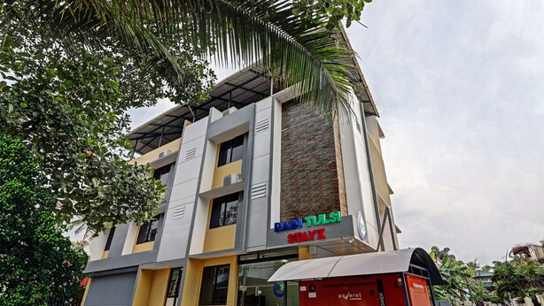 A multi-story building with a modern design, featuring a reception area and signage for "RAIN TOAST STAYZ". - Itsy Hotels Rain Tulsi Stayz, Palarivattom Junction (Kanayannur)