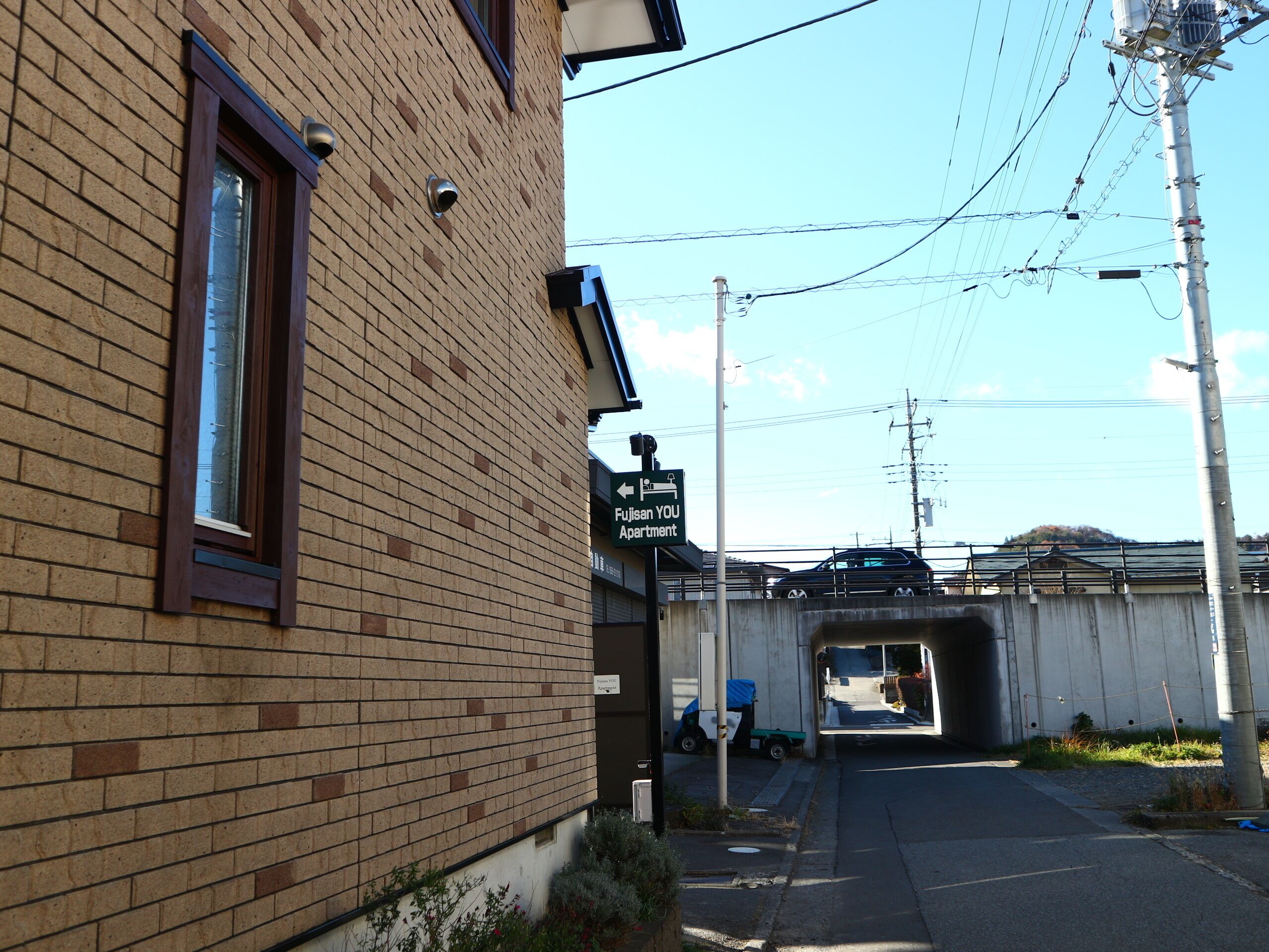 A brick building with a sign indicating a 'Fujisan YOU Apartment'.
