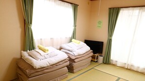 A room with tatami mats, two massage beds, a TV, and a trash bin. - Fujisan YOU Apartment (Fujiyoshida)