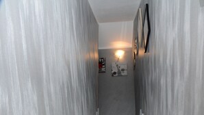 A marble staircase leading to a landing with a wall-mounted light fixture and framed artwork. - City House. Life in the center. (Campofelice di Roccella)