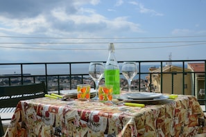 A table set with plates, glasses, and a bottle, overlooking a scenic view.