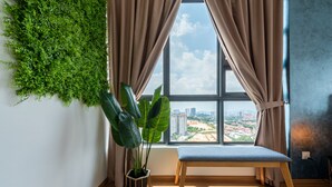 A room with a large window, a bench, a potted plant, and a wall-mounted green plant. - Ekocheras (Kuala Lumpur)