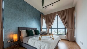 A modern bedroom with a large bed, a bedside table with a lamp, and a view of the city through large windows. - Ekocheras (Kuala Lumpur)