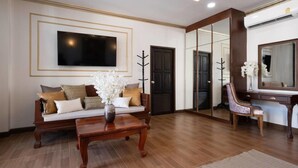 Una sala de estar con un sofá, una mesa de centro y un televisor montado en la pared.