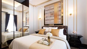 Habitación de hotel con una cama grande, una mesita de noche, un espejo y una obra de arte colgada en la pared.