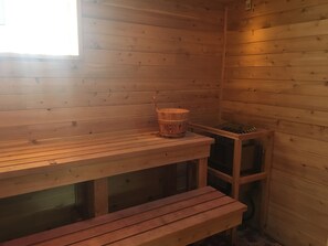 Ein Holzsaunaraum mit Bänken und einem Holzeimer.