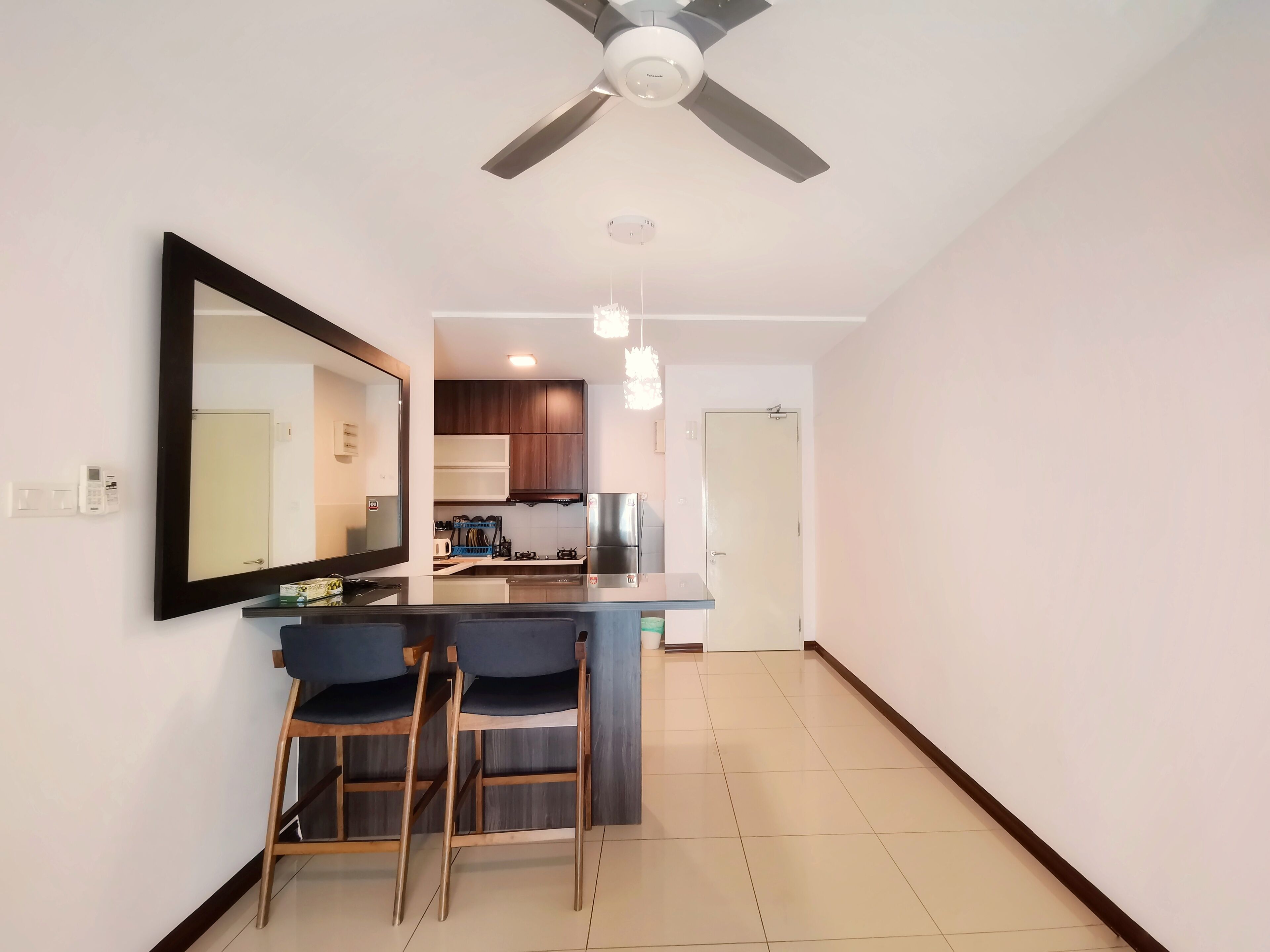 Una cocina moderna con armarios de madera oscura, estufa integrada y una isla grande con taburetes de bar.