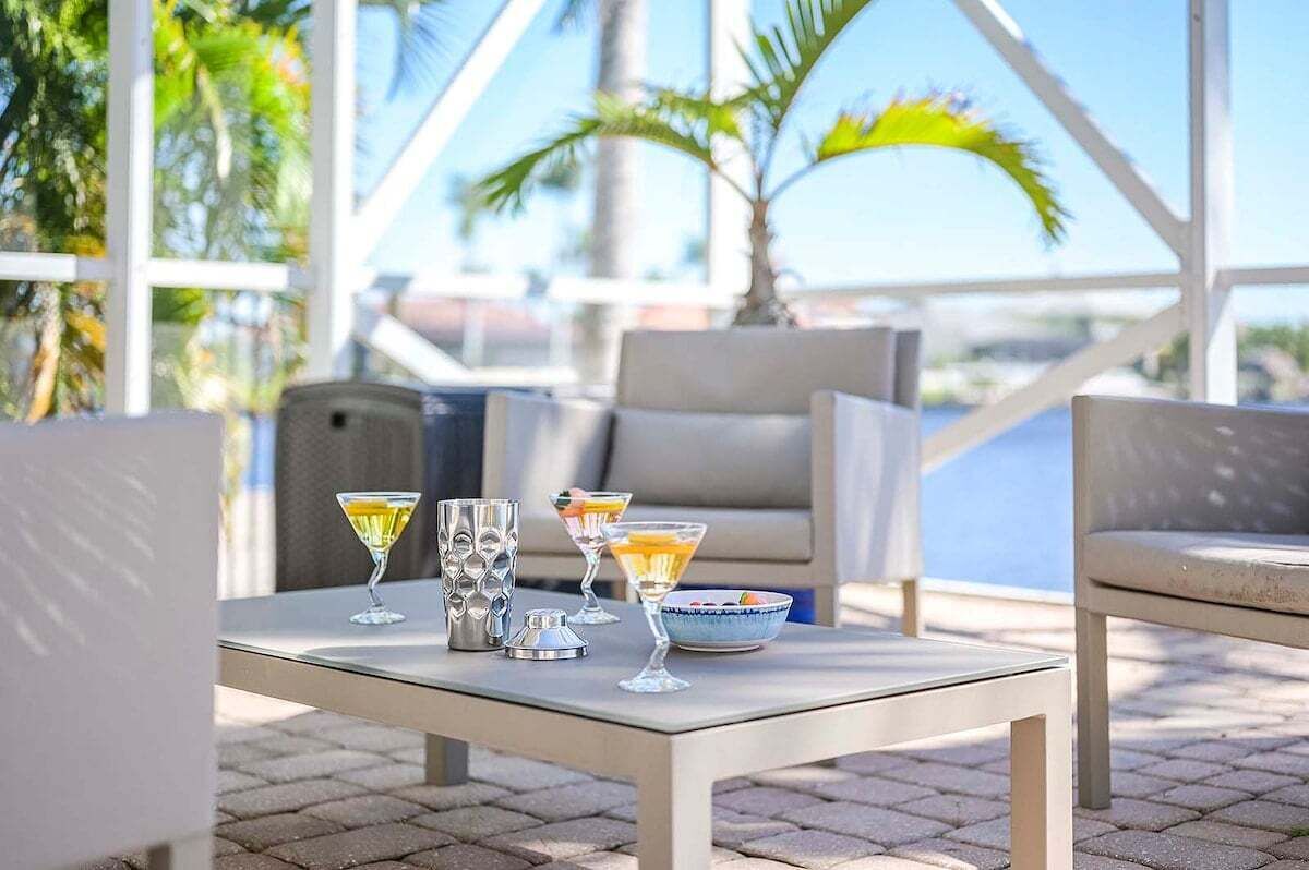 Un espace extérieur aménagé avec une table, des chaises et une vue sur l’océan.