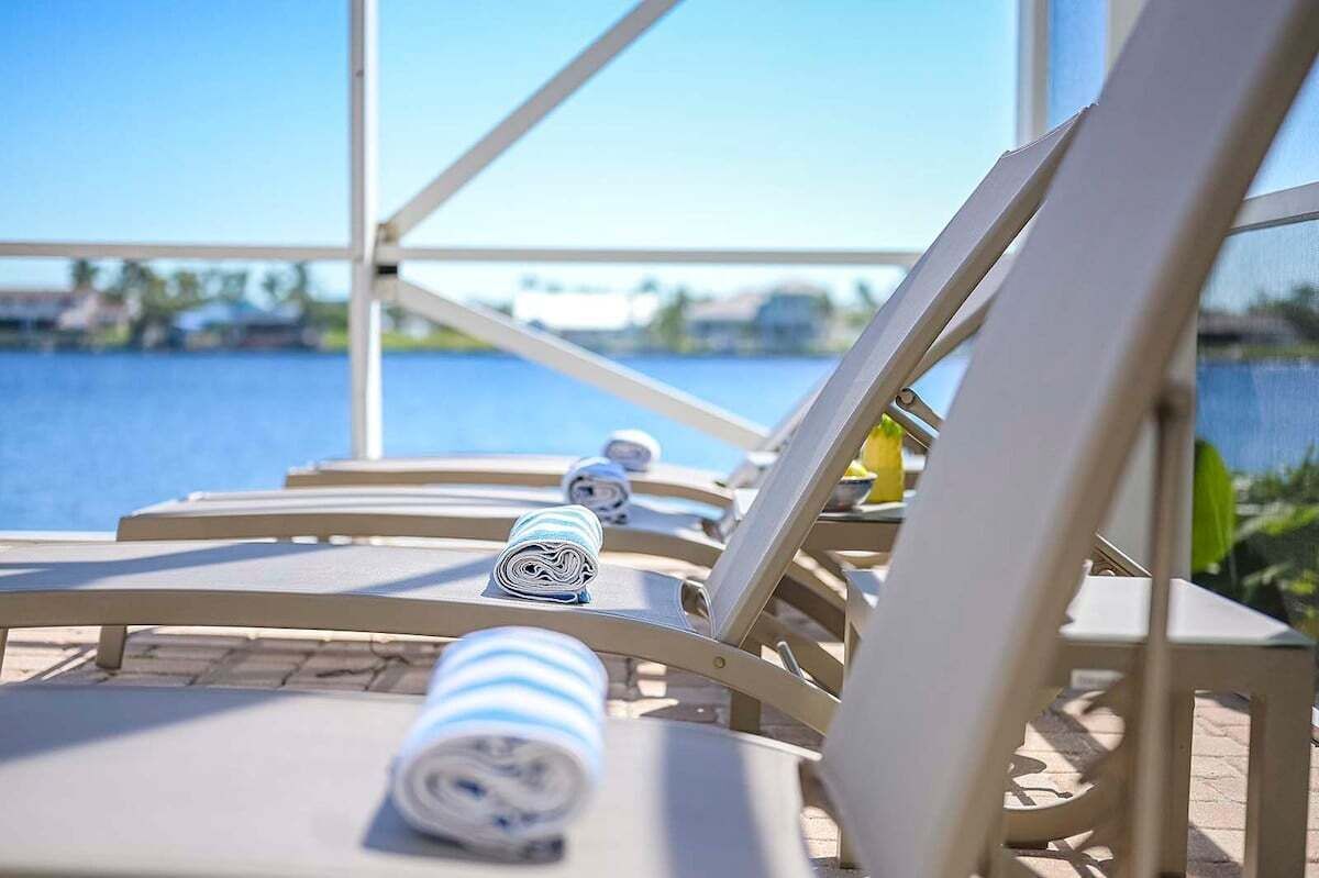 Un espace aménagé au bord de la piscine, avec des chaises longues et une vue sur l’eau.