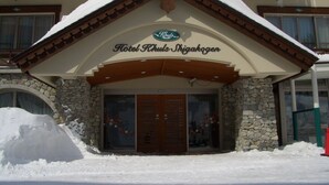 Hotel Khuls Shigakogen with a stone facade and wooden entrance. - Hotel Khuls Shigakogen (Yamanouchi)