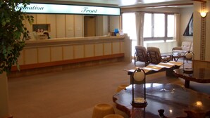 A reception area with a reception desk, chairs, a table, and a plant. - Hotel Khuls Shigakogen (Yamanouchi)