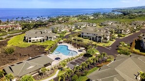 Ett semesterhotell med flera byggnader, en swimmingpool och utsikt över havet.