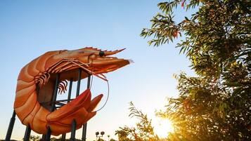 A large sculpture of a shrimp in an outdoor setting.