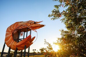 A large sculpture of a shrimp in an outdoor setting.