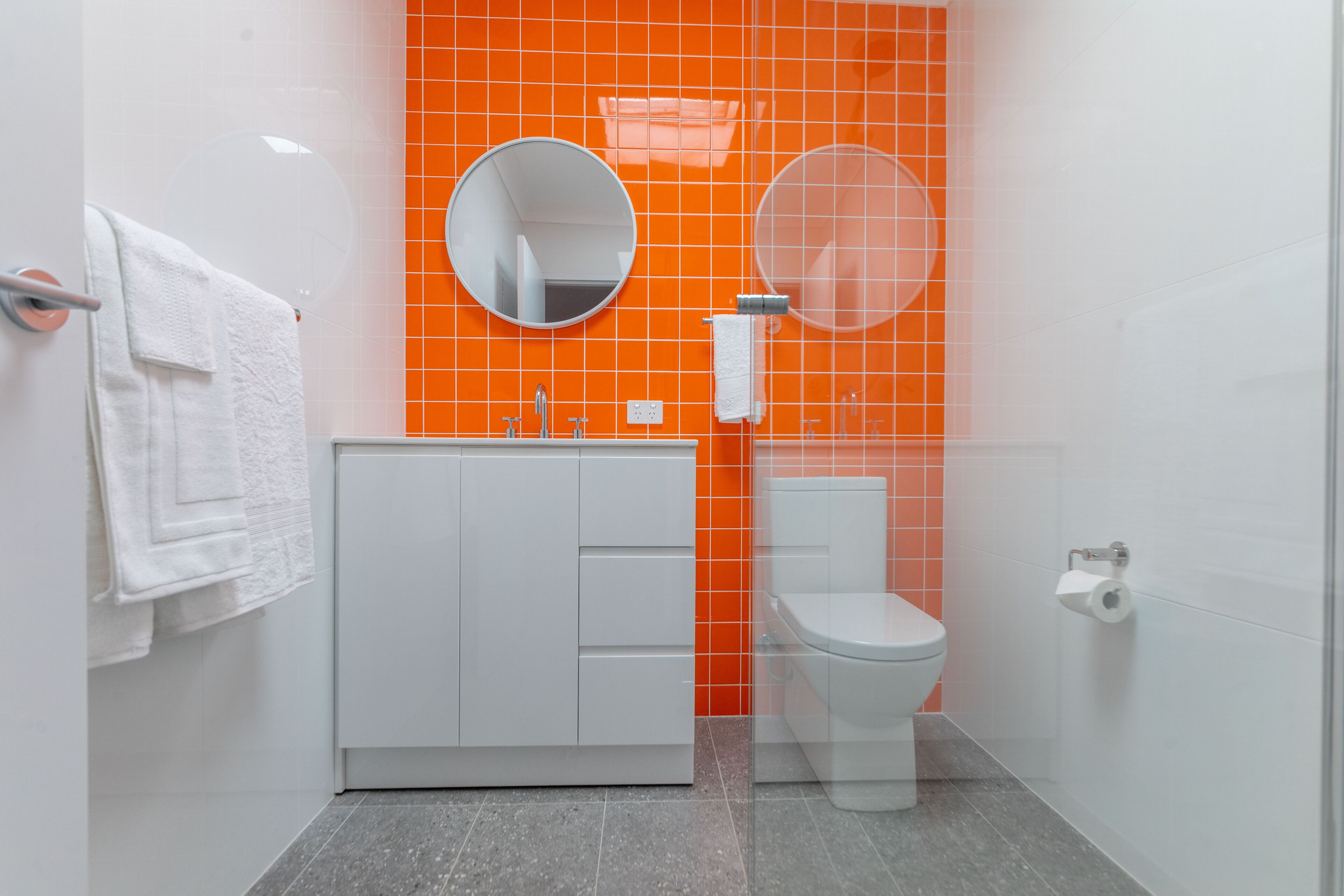 A bathroom with a white sink, a toilet, and a mirror.