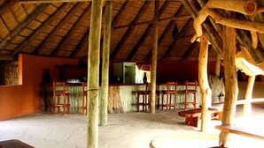 A rustic wooden structure with a thatched roof, wooden benches, and a simple layout. - Jumbo Junction (Gunotsoga)