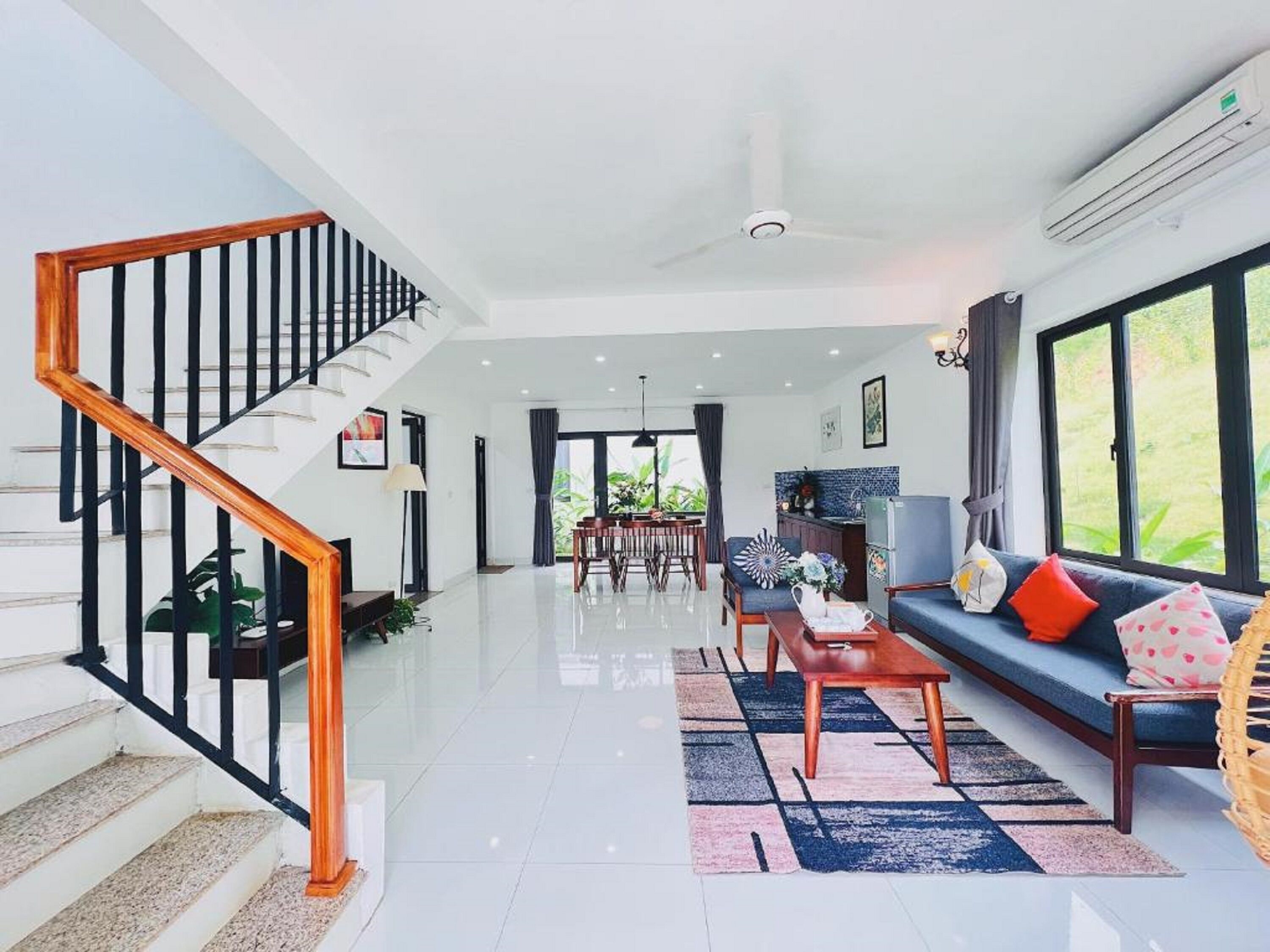 A spacious living area with a staircase, a dining area, and a kitchen.