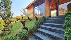 A modern building with a wooden exterior, large windows, and a stone staircase leading to the entrance.
