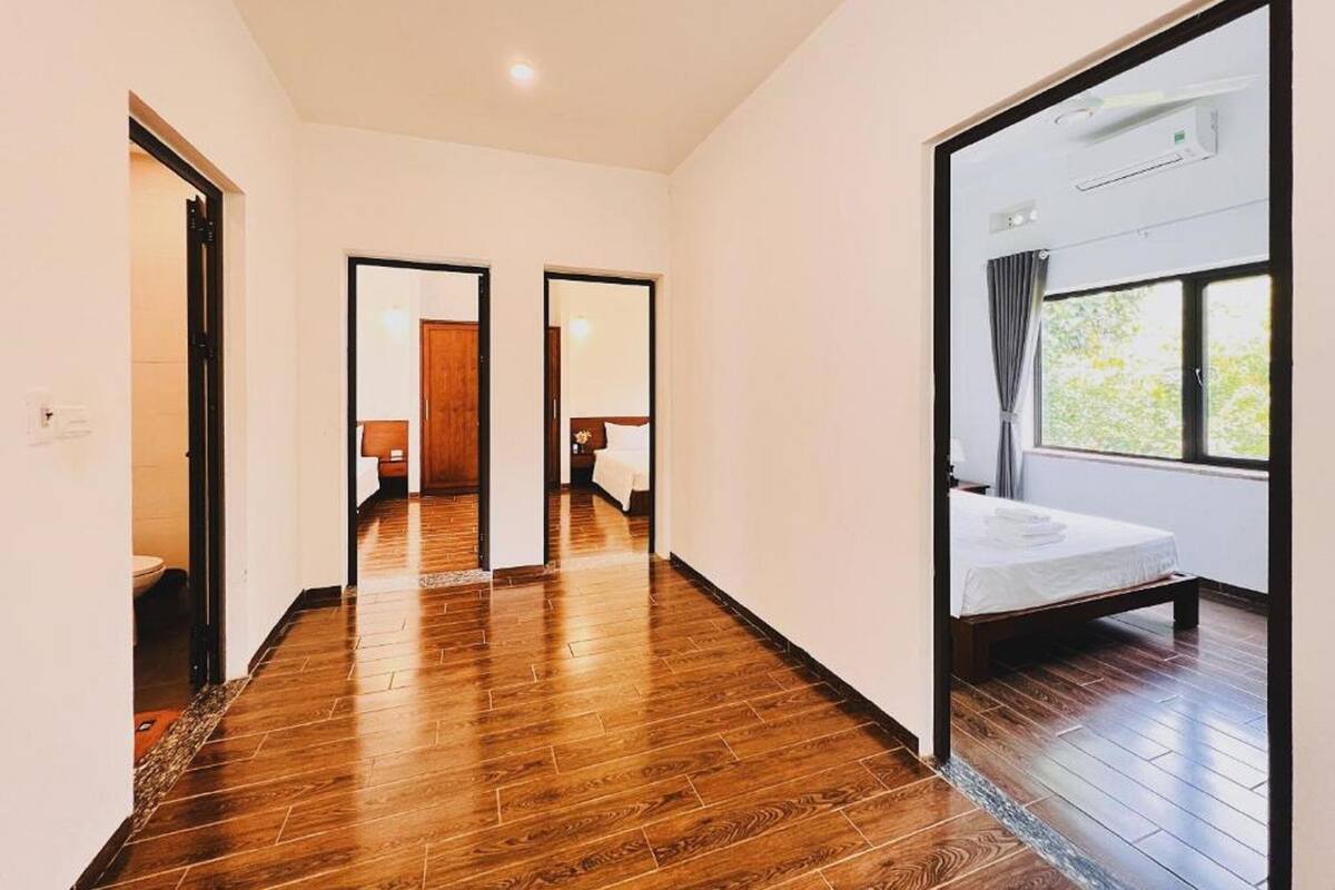 Una habitación de hotel con un ventanal grande, suelo de madera y una cama.