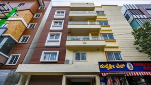 A multi-story building with a ground-level shop featuring a sign in a foreign script. - Zenith Residency (Bengaluru)
