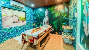 Ein Zimmer mit einer hölzernen Bank, einem Massagetisch und einem Wandgemälde einer Buddha-Statue.
