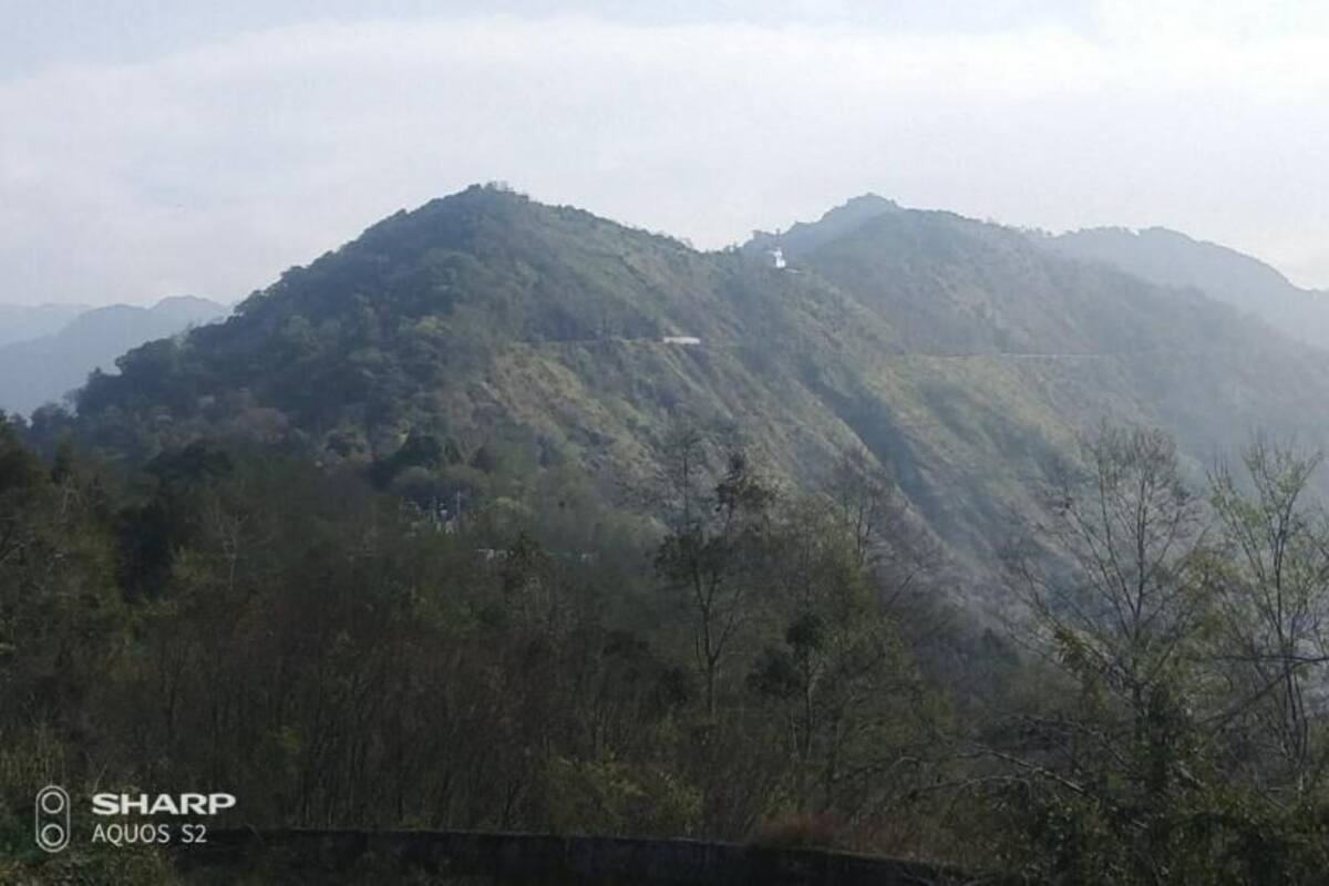 A mountainous landscape with a road winding through the hills.