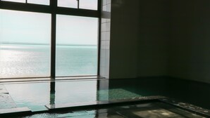 A room with a large window overlooking a body of water, a tiled floor, and a small pool area. - Hotel & Resort Izunone (Higashiizu)