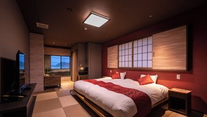 Une chambre d’hôtel moderne dotée d’un grand lit, d’une télévision, d’un bureau et offrant une vue sur l’océan.