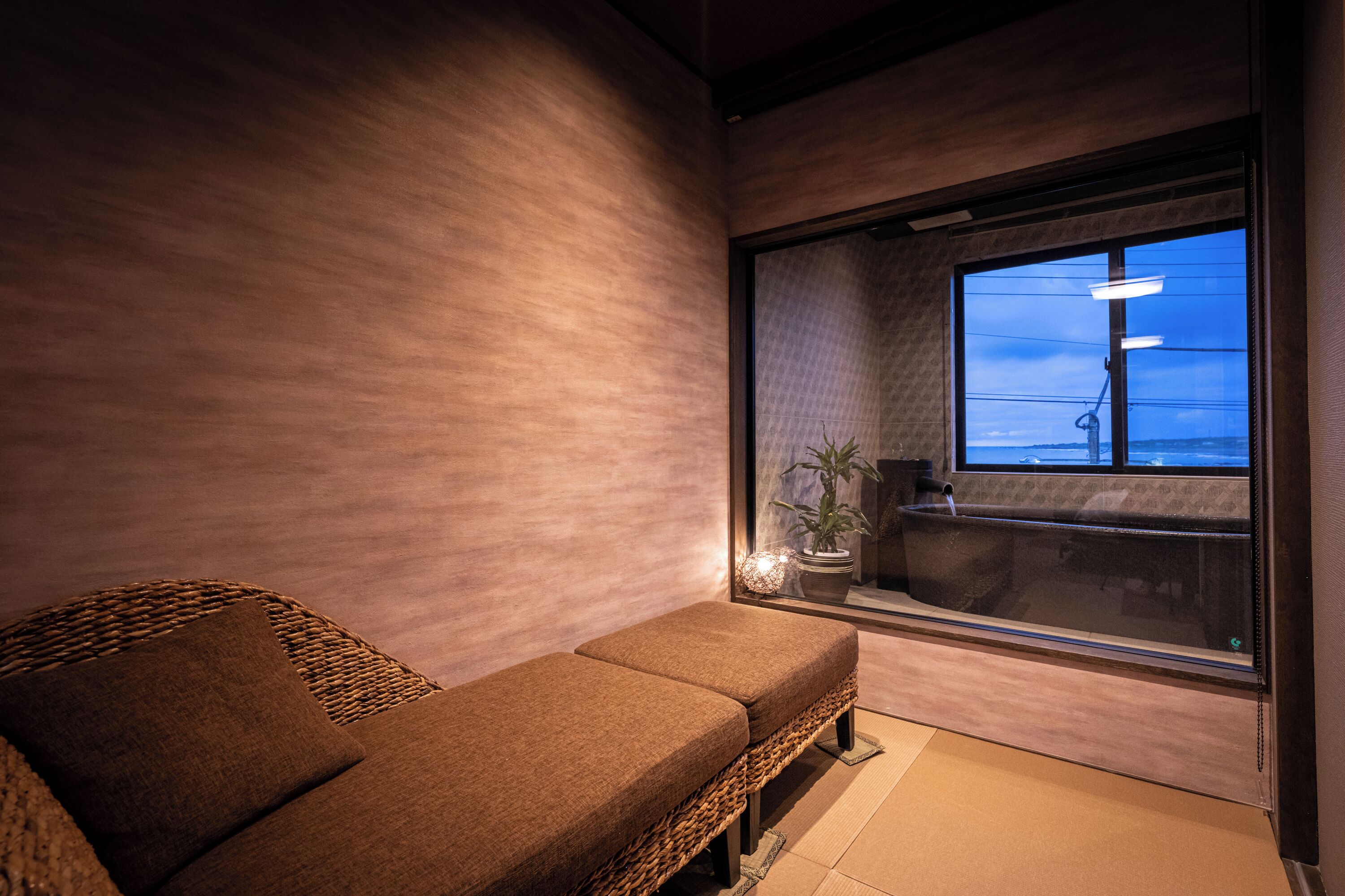 A modern room with a brown sofa, a large window, and a view of the cityscape.