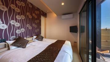 A hotel room with a large bed, a view of the outside balcony, and a patterned wall.