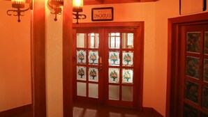 A hallway with a red door, a sign reading "Lounge," and three wall-mounted light fixtures. - Hotel Ryuo Village (Yamanouchi)