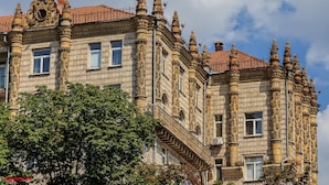 Un edificio storico con dettagli architettonici decorati, tra cui un orologio e numerose finestre.
