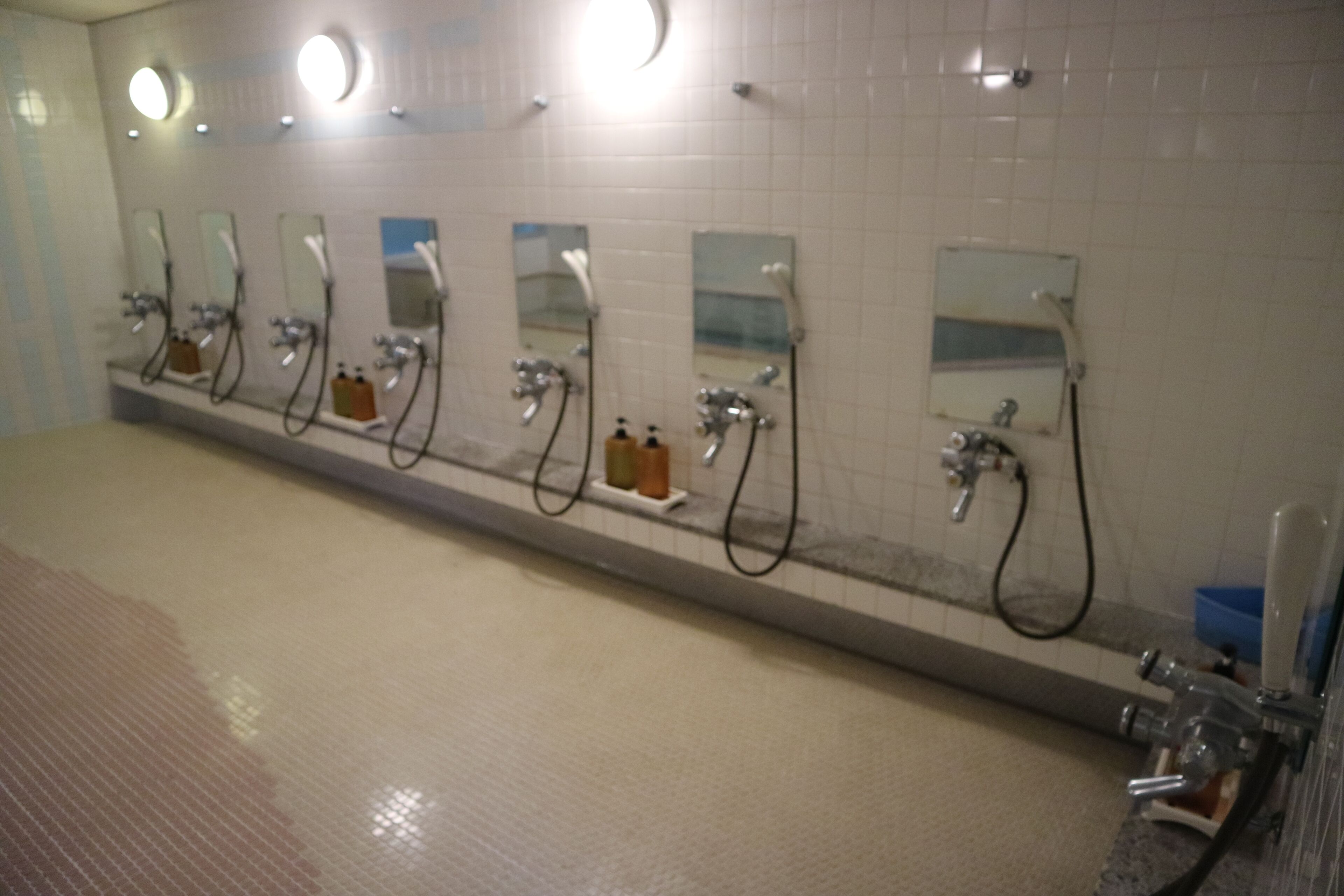 A public restroom with multiple sinks, mirrors, and hand dryers.