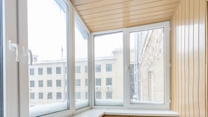 A corner room with wooden walls, a bench, and large windows overlooking a cityscape. - Apartments Kreshchatik 17-21 (Kyiv)