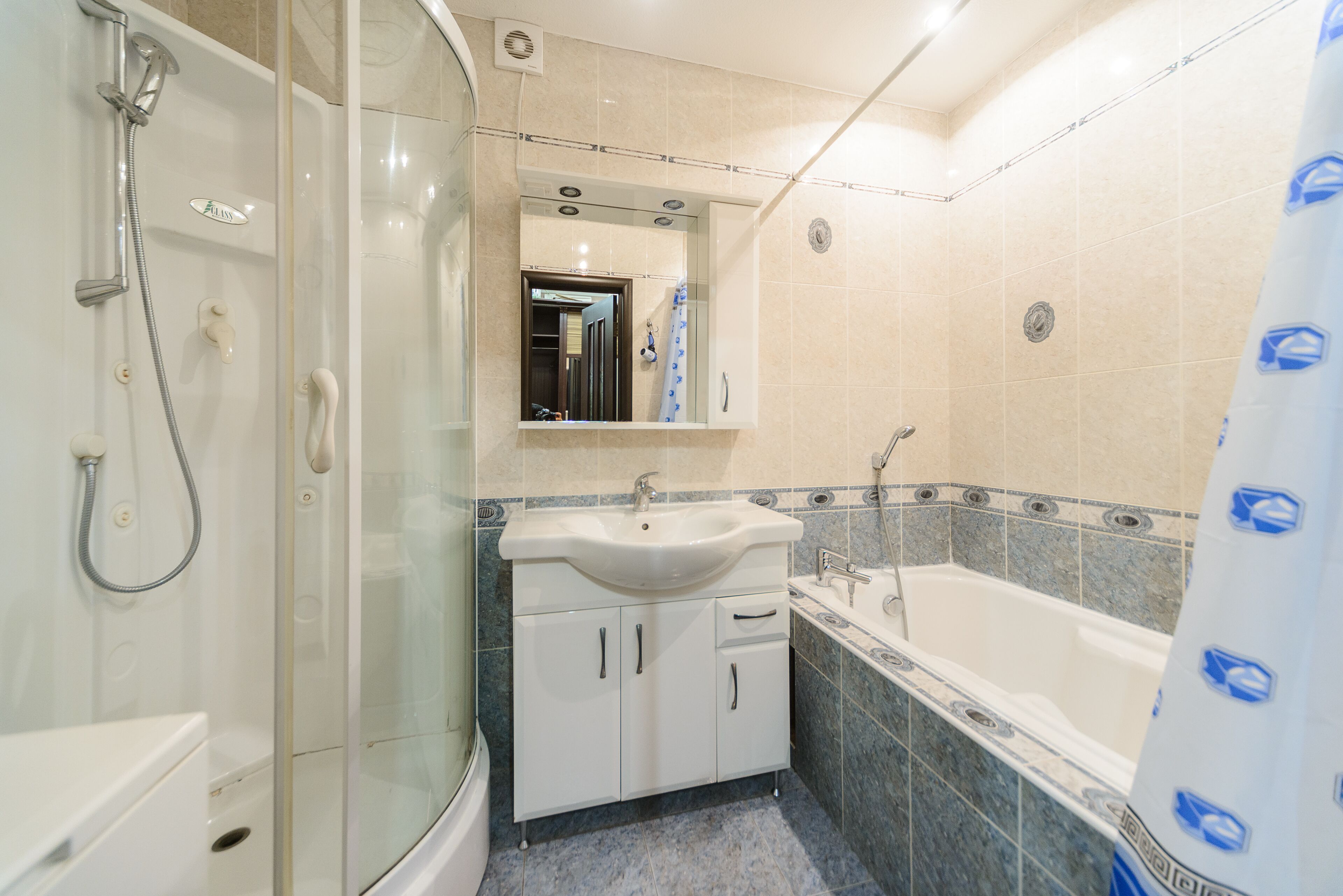 Un baño con ducha envuelta en vidrio, un lavamanos y una bañera.
