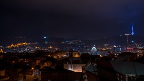 A nighttime cityscape with illuminated buildings and a prominent tower. - Hotel Tbilisi Story (Tbilisi)