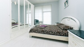 Una camera da letto con un letto, un armadio, una televisione e un quadro appeso al muro.