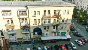 Un edificio a più piani con un ristorante al piano terra e diverse auto parcheggiate.