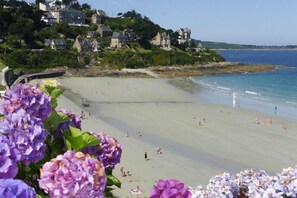 Enjoy a lively beach scene with traditional architecture and lush greenery.
