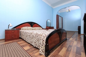 A bedroom with a wooden bed, a nightstand, a dresser, and a mirror.