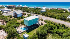 A coastal property with a large turquoise building, a swimming pool, and a road leading to the beach. - HEAVENLY VIEW: Spacious & Beautiful 30A Home with Pool, Huge Deck, Steps to Beach! (Santa Rosa Beach)
