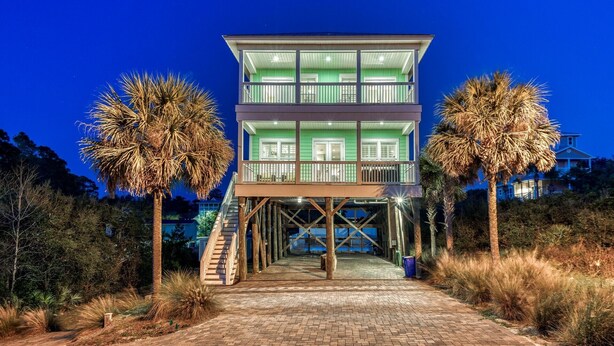 A multi-story building with a glass facade, a staircase leading to a deck, and palm trees on either side. - HEAVENLY VIEW: Spacious & Beautiful 30A Home with Pool, Huge Deck, Steps to Beach! (Santa Rosa Beach)