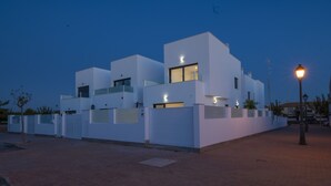 Un edificio moderno con techo plano, ventanas grandes y una entrada bien iluminada.