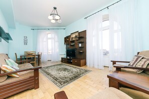 A living room with a sofa, a coffee table, a TV stand, and a bookshelf. - Apartments Kreshchatik 27-28 (Kyiv)