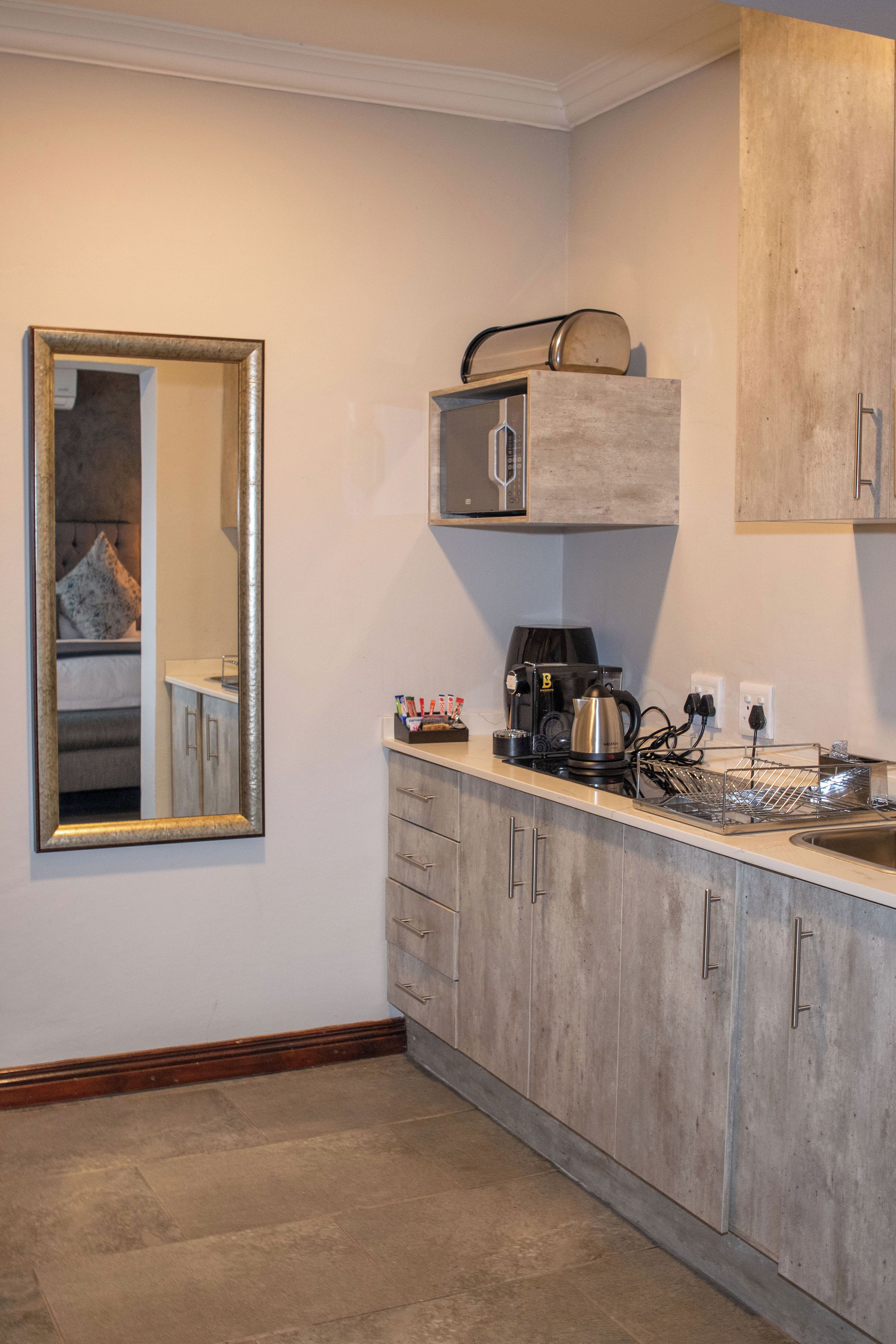 A kitchen with a built-in oven, a coffee maker, and a microwave.